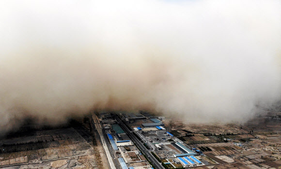 지난 25일 중국 북서부 간쑤성 장예시 린쩌현 일대 아파트와 공장 위를 황사 바람이 뒤덮고 있다. 기상청은 고비사막에서 시작된 이 황사가 남동쪽으로 향해 28일쯤 한국에 불어올 가능성이 있다고 예보했다. 간쑤성 AFP 연합뉴스