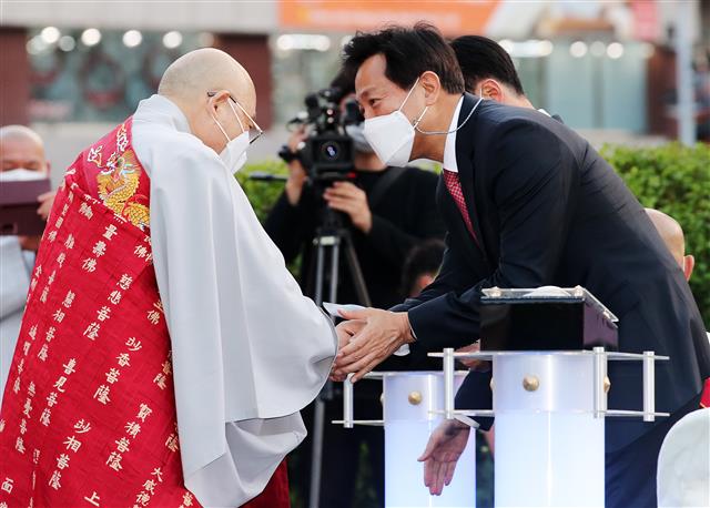 28일 오후 서울시청 앞 광장에서 부처님오신날을 앞두고  열린 봉축점등식에서 오세훈 서울시장이 불교계 지도자들과 인사를 나누고 있다. 올해 부처님오신날 연등행렬은 신종 코로나바이러스 감염증 예방을 위해 온라인으로 열린다. 2021.4.28 뉴스1