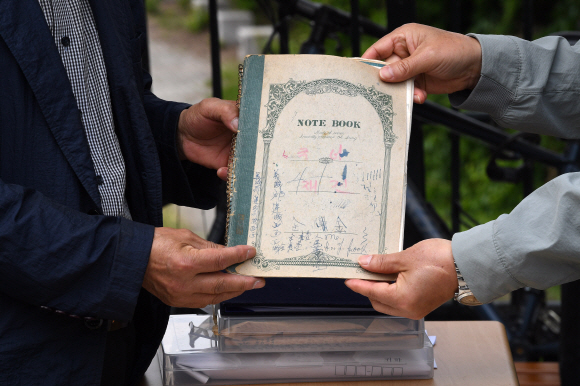 전태일 일기장 관리위원회 회원들이 29일 서울 청계천 전태일 열사 동상 앞에서 전태일 일기장 육필 원본 공개 기자회견을 열고 있다. 전태일 열사의 동생 전태삼 씨가 열사의 육필 일기장을 공개하고 있다. 2021.4.29 오장환 기자 5zzang@seoul.co.kr