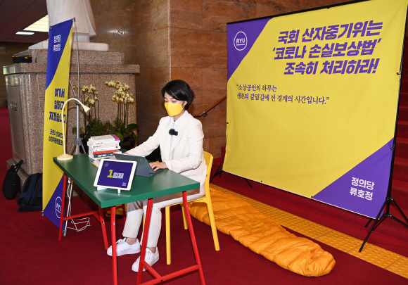 류호정 정의당 의원이 29일 오후 서울 여의도 국회 로텐더홀 앞에서 ‘코로나 손실보상법’ 처리 촉구 농성 돌입 기자회견을 마치고 한켠에 마련한 간이 사무실에서 업무를 보고 있다. 2021. 4. 29 김명국 선임기자 daunso@seoul.co.kr