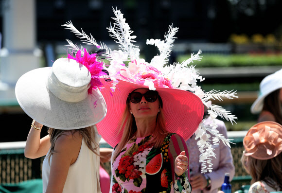 30일(현지시간) 미국 켄터키주 루이빌 처칠다운 경마장에서 유명 경마대회 ‘컨터키 더비’가 열린 가운데 화려한 의상과 독특한 모자를 쓴 관람객이 마스크를 착용하지 않은채 관람하고 있다. UPI 연합뉴스