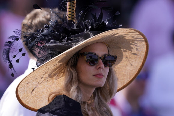 30일(현지시간) 미국 켄터키주 루이빌 처칠다운 경마장에서 유명 경마대회 ‘컨터키 더비’가 열린 가운데 화려한 의상과 독특한 모자를 쓴 관람객이 마스크를 착용하지 않은채 관람하고 있다. AP 연합뉴스