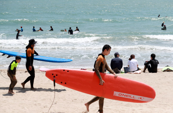 초여름 날씨를 보인 3일 오후 부산 해운대구 송정해수욕장에서 서퍼들이 서핑을 즐기고 있다. 2021.5.3  연합뉴스