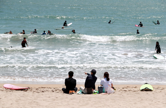 초여름 날씨를 보인 3일 오후 부산 해운대구 송정해수욕장에서 서퍼들이 서핑을 즐기고 있다. 2021.5.3  연합뉴스