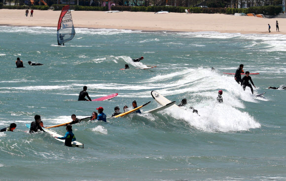 초여름 날씨를 보인 3일 오후 부산 해운대구 송정해수욕장에서 서퍼들이 서핑을 즐기고 있다. 2021.5.3  연합뉴스