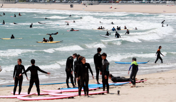 초여름 날씨를 보인 3일 오후 부산 해운대구 송정해수욕장에서 서퍼들이 서핑을 즐기고 있다. 2021.5.3  연합뉴스