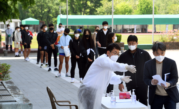 학교에 코로나19 이동식 검사소가 시범 도입된 3일 서울 송파구 서울체육중·고등학교에서 교직원과 학생들이 유전자증폭검사(PCR)를 받기 위해 순서를 기다리고 있다. 사진공동취재단