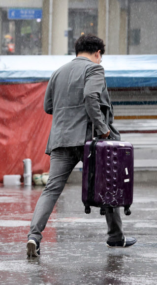 수도권 지역에 비가 내리는 4일 오전 서울역에서 한 시민이 비를 맞으며 뛰어가고 있다. 2021.5.4  연합뉴스