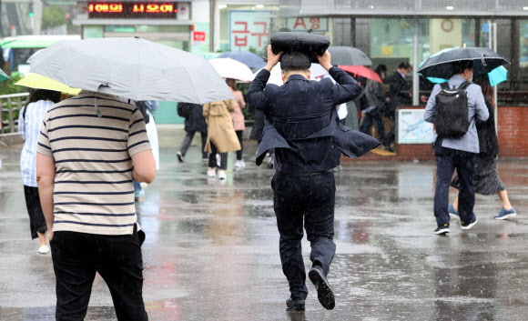 수도권 지역에 비가 내리는 4일 오전 서울역에서 한 시민이 가방으로 비를 막으며 뛰어가고 있다. 2021.5.4 연 합뉴스