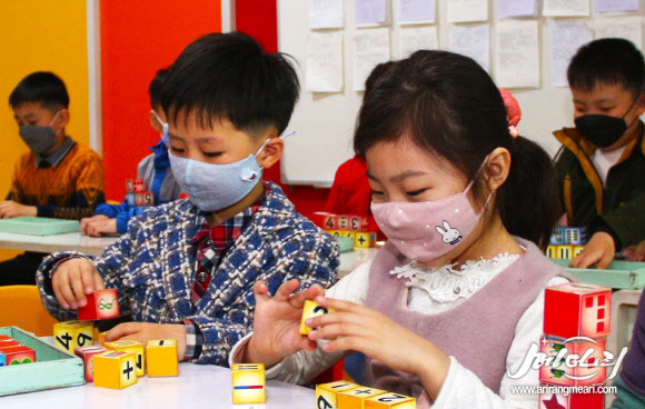 블록 놀이하는 북한 어린이, 마스크엔 토끼 캐릭터