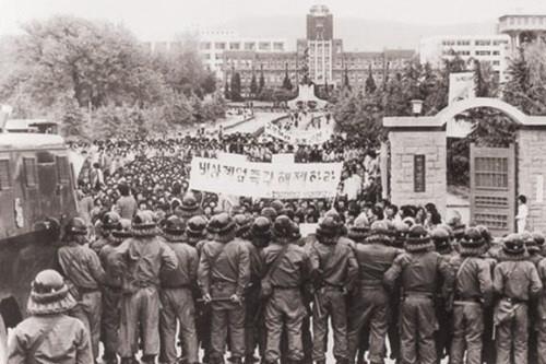 5·18 직전 전남대 정문에서 ‘계엄 해제’를 요구하는 학생들 앞에 전투 경찰이 서 있다.  서울신문 DB