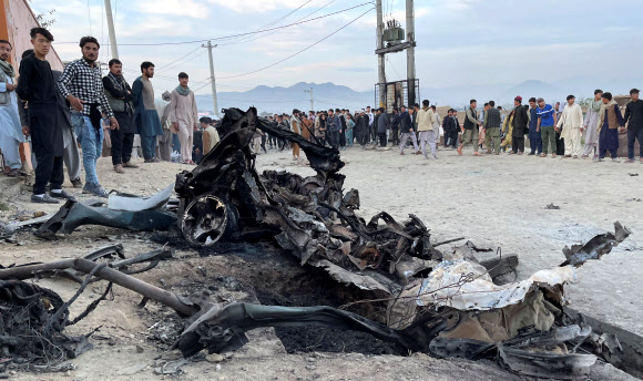 아프가니스탄 카불에서 최소 50명이 숨지는 차량 폭탄테러가 발생한 8일(현지시간) 시민들이 불에 타 형체를 알아보기 힘들 정도로 망가진 자동차의 잔해를 둘러싸고 있다. 카불 로이터 연합뉴스