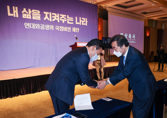 이낙연 전 더불어민주당 대표가 10일 오전 서울 용산구 백범김구기념관 컨벤셜홀에서 싱크탱크 ‘연대와 공생’ 주최로 열린 정책 심포지엄에서 송영길 당대표와 악수를 나누고 있다.2021. 5. 10 오장환 기자 5zzang@seoul.co.kr