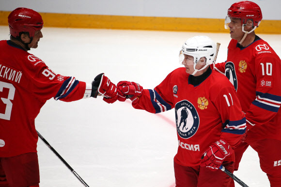 블라디미르 푸틴(오른쪽) 러시아 대통령이 10일(현지시간) 흑해 연안 휴양 도시 소치의 볼쇼이 아이스 돔에서 자선행사로 열린 아마추어 아이스하키 경기에서 동료 선수와 주먹인사를 하고 있다. 타스 연합뉴스