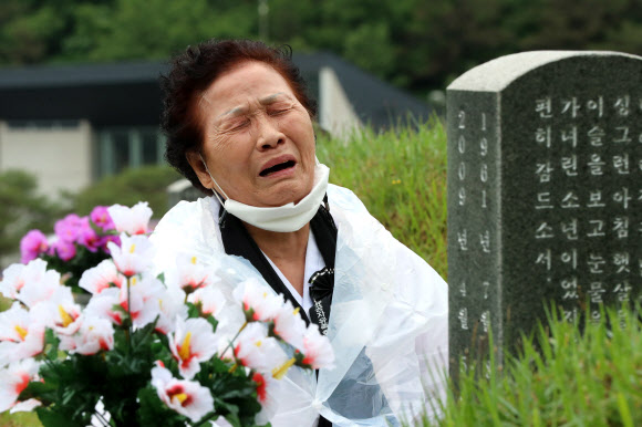 제41주년 5·18민주화운동 기념일을 하루 앞둔 17일 오전 광주 북구 5·18 민주묘지에서 추모제가 열려 유족이 눈물을 흘리며 가족 열사 묘역을 참배하고 있다. 2021.5.17  연합뉴스