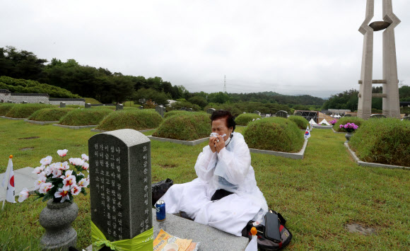 제41주년 5·18민주화운동 기념일을 하루 앞둔 17일 오전 광주 북구 5·18 민주묘지에서 추모제가 열려 유족이 눈물을 흘리며 가족 열사 묘역을 참배하고 있다. 2021.5.17  연합뉴스