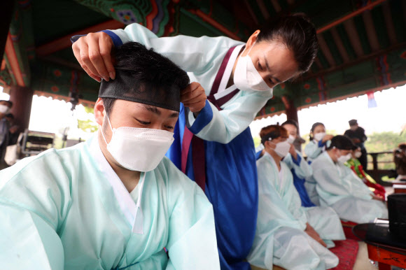 17일 서울 중구 남산골한옥마을 천우각에서 열린 ‘서울시 성년의 날 기념행사’에서 올해 만 19세가 되는 2002년생 청소년들이 의복 및 족두리를 착용하는 가례 의식을 하고 있다. 2021.5.17  연합뉴스