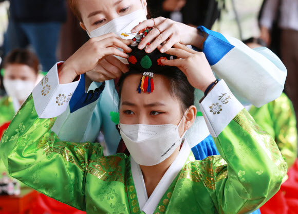 성년의 날인 17일 오전 서울 중구 남산골 한옥마을에서 열린 제49회 전통 성년례 재현행사에서 참석자들이 의복 및 족두리를 착용하는 가례 의식을 하고 있다. 2021.5.17  연합뉴스