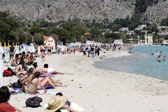 16일(현지시간) 이탈리아 시칠리아의 몬델로 해변이 재개장 하자 시민들이 일광욕을 즐기고 있다. AP 연합뉴스