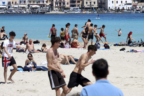 16일(현지시간) 이탈리아 시칠리아의 몬델로 해변이 재개장 하자 시민들이 일광욕을 즐기고 있다. AP 연합뉴스