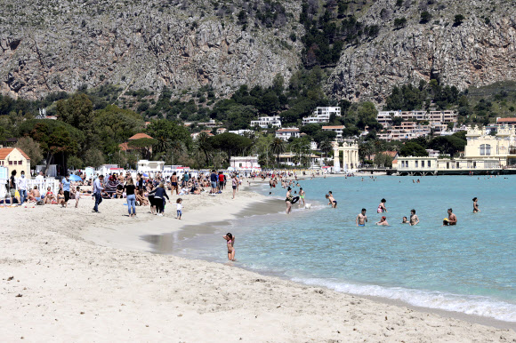 16일(현지시간) 이탈리아 시칠리아의 몬델로 해변이 재개장 하자 시민들이 일광욕을 즐기고 있다. AP 연합뉴스