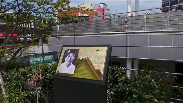 김명시의 생가가 있었던 오동동 문화광장 화단에 설치된 김명시 생가 표지판.