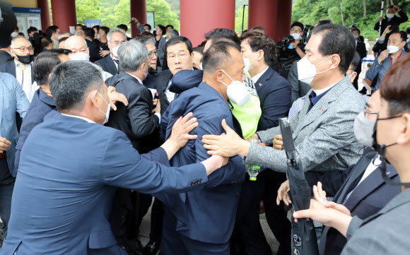 제41주년 5·18민주화운동 기념일인 18일 오전 기념식이 열리는 광주 북구 국립 5·18 민주묘지 입구에서 5·18 구속부상자회 문흥식 회장의 입장을 반대파들이 막아서면서 몸싸움이 벌어지고 있다. 2021.5.18  연합뉴스