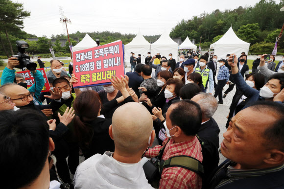 제41주년 5·18민주화운동 기념일인 18일 오전 기념식이 열리는 광주 북구 국립 5·18 민주묘지 입구에서 5·18 구속부상자회 문흥식 회장의 입장을 반대파들이 막아서면서 몸싸움이 벌어지고 있다. 2021.5.18  연합뉴스