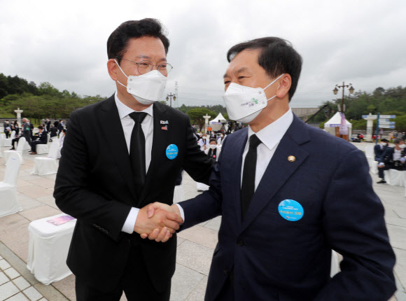 더불어민주당 송영길 대표(왼쪽)와 국민의힘 김기현 당 대표 권한대행 겸 원내대표가 18일 오전 광주 북구 국립 5·18 민주묘지에서 열린 제41주년 5·18 민주화운동 기념식에서 만나 악수하고 있다. 2021.5.18  연합뉴스