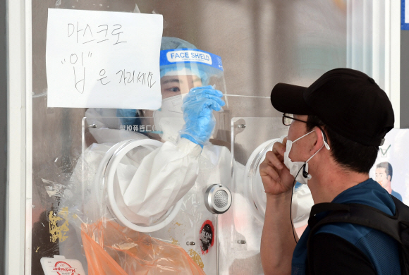 18일 서울 중구 서울역 광장에 마련된 코로나19 임시선별검사소에서 의료진이 시민들의 검체검사를 하고 있다. 박윤슬 기자 seul@seoul.co.kr
