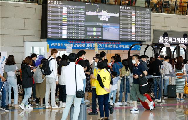 석가탄신일인 19일 오전 서울 강서구 김포국제공항 국내선 청사에서 여행객들이 체크인을 하기 위해 길게 줄 서 있다. 2021.5.19 뉴스1