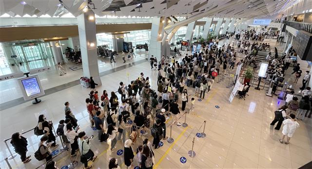 석가탄신일인 19일 오전 서울 강서구 김포국제공항 국내선 청사에서 여행객들이 체크인을 하기 위해 길게 줄 서 있다. 2021.5.19 뉴스1