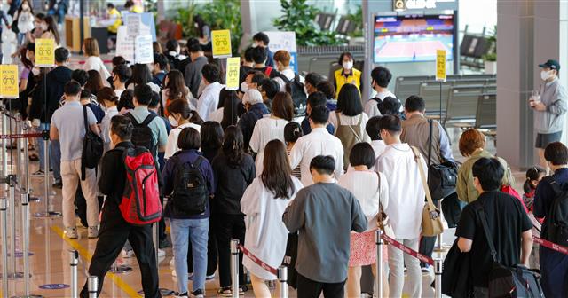 석가탄신일인 19일 오전 서울 강서구 김포국제공항 국내선 청사에서 여행객들이 체크인을 하기 위해 길게 줄 서 있다. 2021.5.19 뉴스1