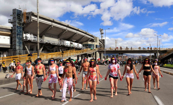 행위 예술가들이 19일(현지시간) 콜롬비아 보고타의 엘 캄핀 스타디움 밖에서 아르헨티나와 공동 주최하는 ‘2021 코파 아메리카 대회’ 개최를 반대하는 퍼포먼스를 하고 있다. AFP 연합뉴스
