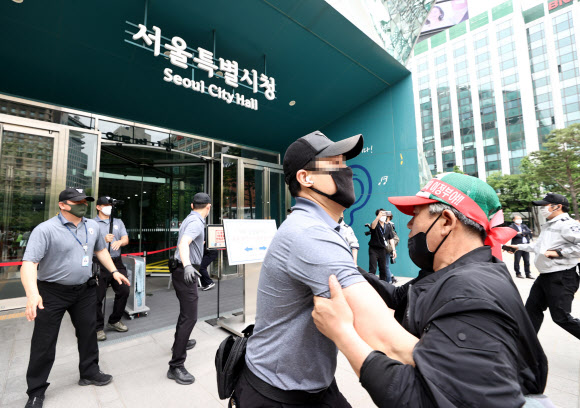 20일 오후 한국유흥음식업중앙회·한국단란주점업중앙회·한국콜라텍협회 관계자 및 업주들이 정부에 집합금지 해제 및 손실보상법 통과를 촉구하며 서울 중구 서울시청 내부로 진입하던 중 경찰과 대치하고 있다. 2021.5.20  연합뉴스