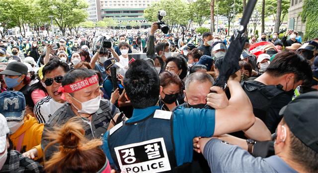 20일 오후 서울시청 앞에서 한국유흥업음식업중앙회, 한국단란주점업중앙회, 한국콜라텍협회 ‘형평성 맞는 방역수칙, 집합금지 해제 촉구 기자회견’을 마친 참가자들이 오세훈 시장 면담 등을 요구하며 경찰과 충돌하고 있다. 2021.5.20 뉴스1