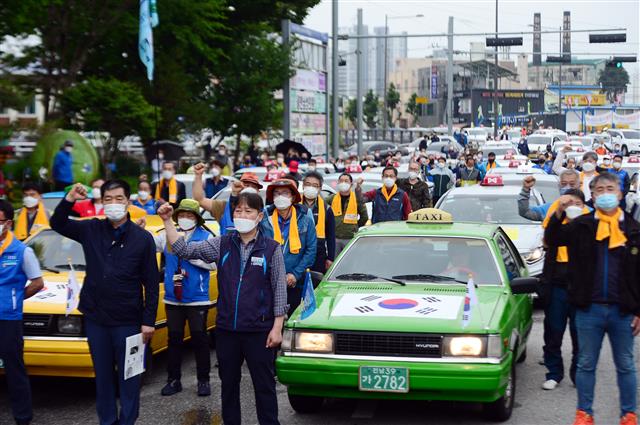 ‘제41주년 5·18민중항쟁 민주기사의 날’을 맞은 20일 오후 광주 북구 무등경기장 앞에서 민주택시노동조합 관계자들이 차량행렬 시위에 앞서 구호를 외치고 있다. 민주택시노동조합은 1980년 5·18민주화운동 당시 시민군의 옛 전남도청 탈환의 기폭제가 됐던 택시 기사들의 차량행렬 시위가 있었던 5월20일을 민주기사의 날로 정하고 1997년부터 매년 이날 차량행렬 시위를 재현해 왔다. 2021.5.20 뉴스1