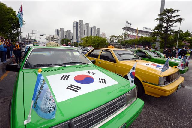 ‘제41주년 5·18민중항쟁 민주기사의 날’을 맞은 20일 오후 광주 북구 무등경기장 앞에서 민주택시노동조합 관계자들이 차량행렬 시위에 앞서 사열을 하고 있다. 민주택시노동조합은 1980년 5·18민주화운동 당시 시민군의 옛 전남도청 탈환의 기폭제가 됐던 택시 기사들의 차량행렬 시위가 있었던 5월20일을 민주기사의 날로 정하고 1997년부터 매년 이날 차량행렬 시위를 재현해 왔다. 2021.5.20 뉴스1