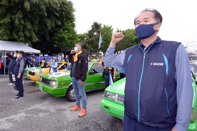 ‘제41주년 5·18민중항쟁 민주기사의 날’을 맞은 20일 오후 광주 북구 무등경기장 앞에서 민주택시노동조합 관계자들이 차량행렬 시위에 앞서 사열을 하고 있다. 민주택시노동조합은 1980년 5·18민주화운동 당시 시민군의 옛 전남도청 탈환의 기폭제가 됐던 택시 기사들의 차량행렬 시위가 있었던 5월20일을 민주기사의 날로 정하고 1997년부터 매년 이날 차량행렬 시위를 재현해 왔다. 2021.5.20 뉴스1