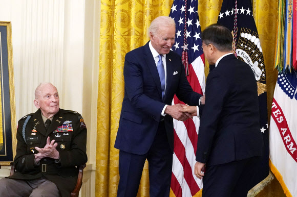 21일(현지시간) 미국 백악관에서 열린 한국전 영웅 명예훈장 수여식에서 조 바이든 미국 대통령과 문재인 대통령이 악수를 하고 있다. AP