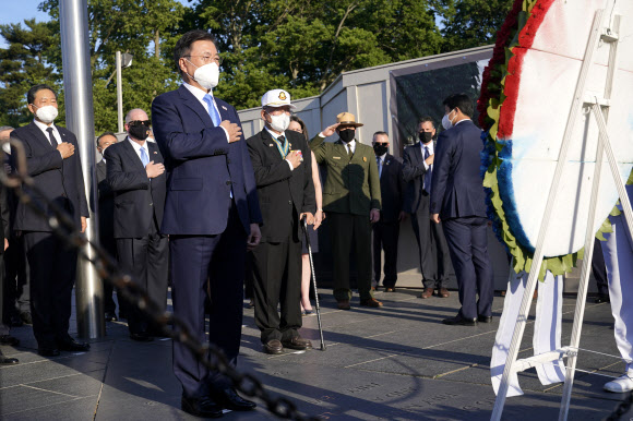 문재인 대통령이 21일(현지시간) 미국 워싱턴 한국전 참전기념비 공원에서 열린 한국전 전사자 추모의 벽 착공식에서 양국 참전용사들과 헌화하고 있다. AP 연합뉴스