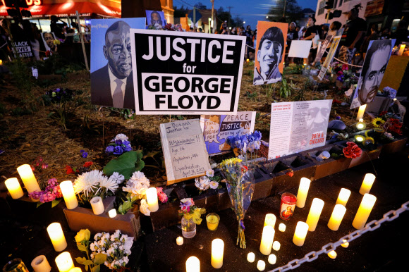 조지 플로이드 사망 1주년인 25일(현지시간) 그가 숨진 장소인 미국 미네소타주 미니애폴리스 조지 플로이드 광장에 경찰에 의해 목숨을 잃은 사람들의 이름과 LED촛불 등이 놓여있다. 미니애폴리스 로이터 연합뉴스