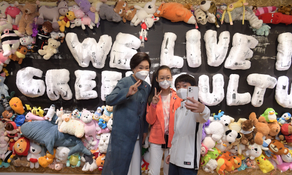 문재인 대통령 부인 김정숙  여사가 26일 서울 종로구 대림미술관에서 열린 ‘2021 P4G 특별 기획 전시회’에서 전시물을 관람하며 어린이들과 셀카를 찍고있다.  2021. 5. 26 도준석 기자 pado@seoul.co.kr