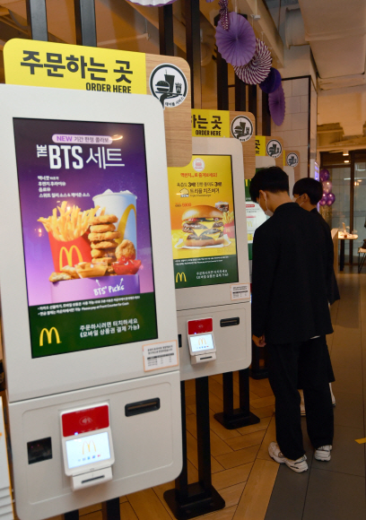 27일 오전 서울 강남구 맥도날드 코엑스점을 찾은 고객들이 방탄소년단과 손잡고 새롭게 출시된 ‘The BTS 세트’를 구매 후 기념사진을 찍고 있다.  맥도날드가 방탄소년단(BTS)와의 협업으로 탄생한 ‘The BTS 세트’는 평소 BTS가 좋아하는 메뉴들인 맥너겟과 후렌치 후라이와 음료, 한국맥도날드에서 개발한 소스로 구성됐으며 이날부터 전 세계 50개국 마켓에서 판매된다. 2021.5.27. 박지환 기자 popocar@seoul.co.kr