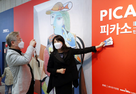 이재명 경기도지사 부부가 29일 오후 서울 서초구 예술의전당에서 열린 ‘피카소 탄생 140주년 특별전’ 관람을 위해 줄을 서 입장을 기다리던 중 사진을 찍고 있다. 2021.5.29  연합뉴스
