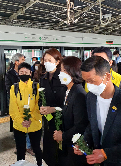 서울지하철 2호선 구의역에서 스크린도어를 혼자 정비하다 열차에 치여 숨진 ‘구의역 김군’의 5주기 다음 날인 29일 서울 광진구 구의역 9-4 승강장에서 열린 추모제에서 더불어민주당 고민정 의원(오른쪽 세번째) 등 참석자들이 국화를 들고 있다. 2021.5.29  연합뉴스
