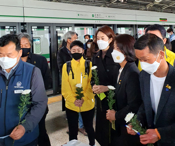 서울지하철 2호선 구의역에서 스크린도어를 혼자 정비하다 열차에 치여 숨진 ‘구의역 김군’의 5주기 다음 날인 29일 서울 광진구 구의역 9-4 승강장에서 열린 추모제에서 더불어민주당 고민정 의원(오른쪽 세번째) 등 참석자들이 국화를 들고 있다. 2021.5.29  연합뉴스