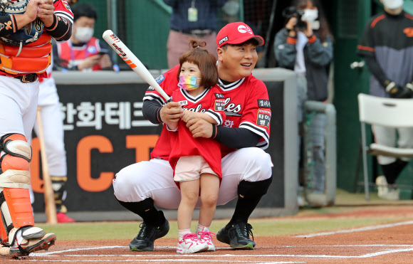 29일 한화생명이글스파크에서 열린 ‘한화 이글스의 레전드 김태균의 은퇴식’에서 김태균이 딸 하린양의 시타를 돕고 있다. 2021.5.29  연합뉴스