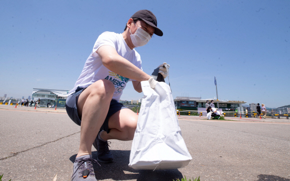 안철수 국민의당 대표가 30일 오전 서울 서초구 한강공원 잠원지구에서 열린 쓰담 원정대 달리기 캠페인에서 쓰레기를 줍고 있다. 2021. 5. 30 국회사진기자단
