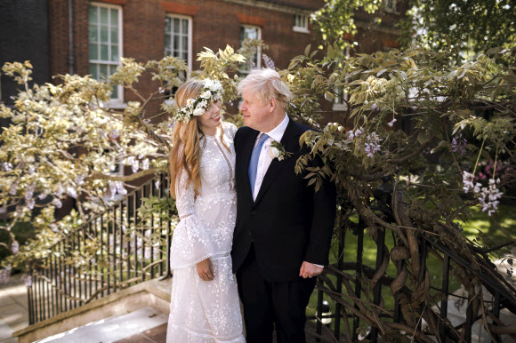 보리스 존슨(오른쪽) 영국 총리와 약혼녀 캐리 시먼즈가 29일(현지시간) 런던 웨스트민스터 대성당에서 결혼식을 올린 뒤 다우닝가 10번지 총리 관저 정원에서 기념 촬영을 하고 있다. 런던 AP 연합뉴스